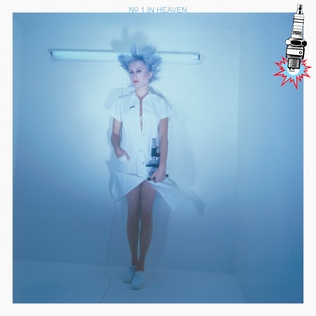 The sleeve of 'Number One in Heaven' by Sparks. A woman in what might be a white nurse's outfit and white gym shoes spotlit in a white room with an unlit fluorescent light behind her head. The man with the small moustache was probably having his hair done at the time.